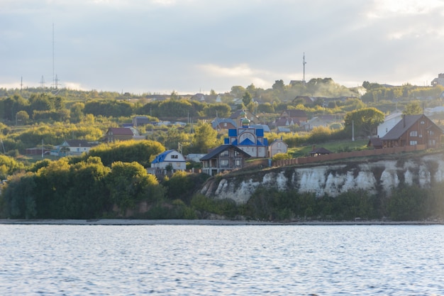 Het kleine dorpje aan de oevers van de rivier de Wolga bedekt met mist in het midden van de Wolga