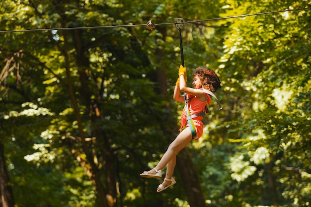 Het kleine meisje gaat langs de zipline in het park