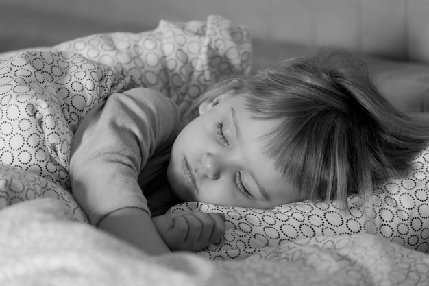 Het kleine meisje slaapt in het bed van de ouders Slapen in een dag Selectieve focus zwart-wit