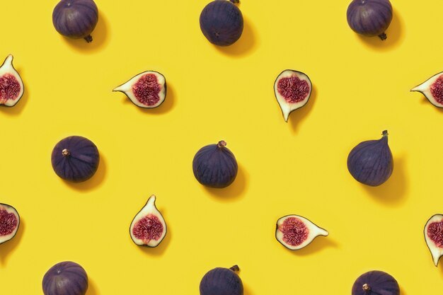 Het kleurrijke verse patroon van het vijgenfruit op helder geel geheel als achtergrond en gesneden fig