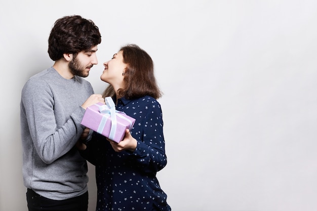 Het knappe jonge man geven thuis aan mooie vrouw thuis.