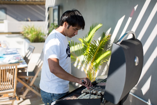 Het knappe mannetje bereidt in openlucht barbecue voor