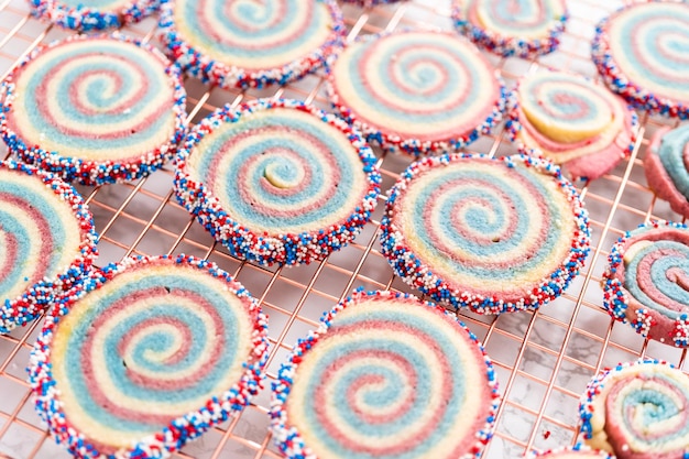 Het koelen van rode, witte en blauwe pinwheel-suikerkoekjes op een koelrek. Dessert voor de viering van 4 juli.