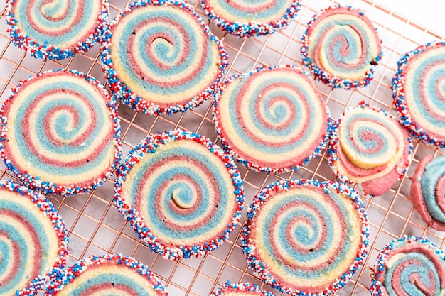 Het koelen van rode, witte en blauwe pinwheel-suikerkoekjes op een koelrek. Dessert voor de viering van 4 juli.