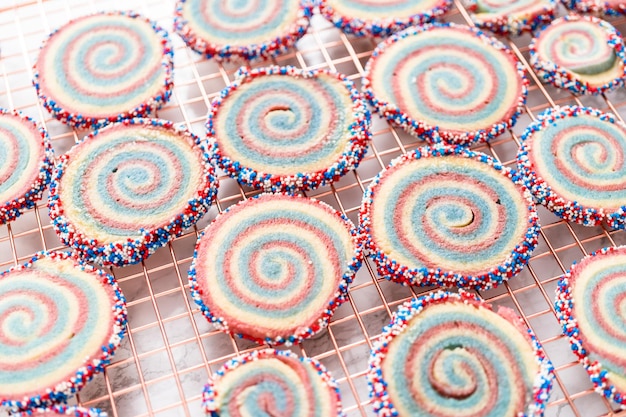 Het koelen van rode, witte en blauwe pinwheel-suikerkoekjes op een koelrek. Dessert voor de viering van 4 juli.