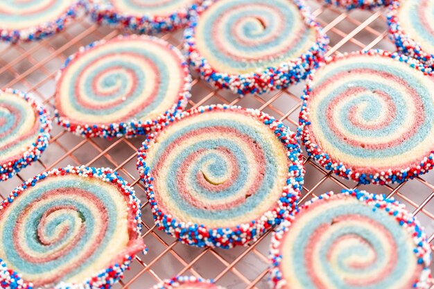 Het koelen van rode, witte en blauwe pinwheel-suikerkoekjes op een koelrek. Dessert voor de viering van 4 juli.