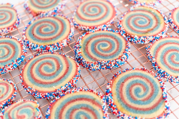 Het koelen van rode, witte en blauwe pinwheel-suikerkoekjes op een koelrek. Dessert voor de viering van 4 juli.