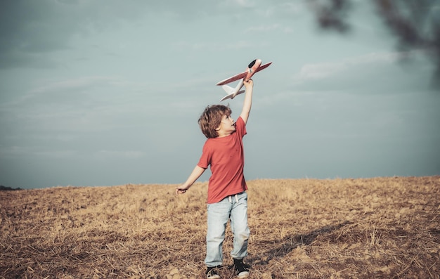 Het koesteren van herinneringen aan actieve kinderen uit de kindertijd concept kind heeft plezier met speelgoedvliegtuig in veld c