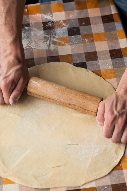 Het koken en huisconcept - sluit omhoog van mannelijke handen knedend deeg