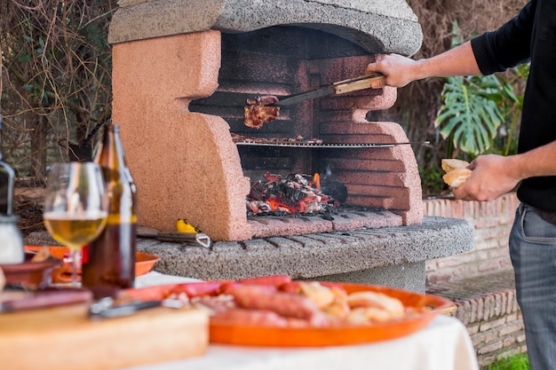 Het koken van de mens vleeslapjes vlees bij de grill in openlucht