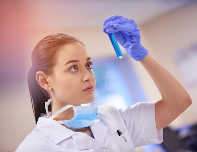 Het komt allemaal neer op deze Shot van een jonge wetenschapper die vloeistof in een reageerbuis in een laboratorium onderzoekt