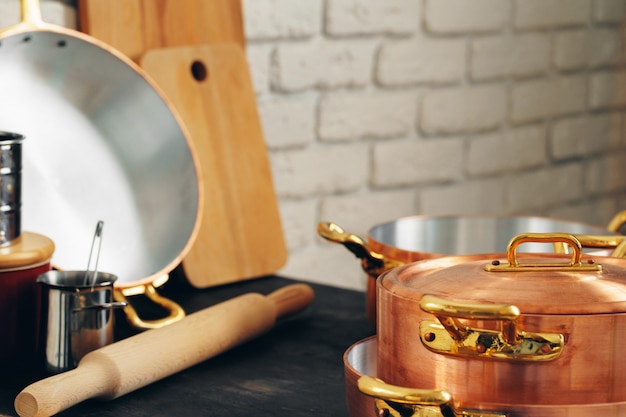 Het koper cookware met houten keukengerei sluit omhoog