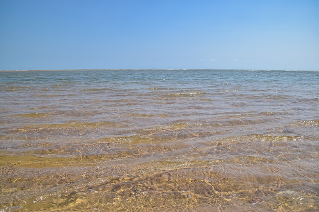 Het kristalheldere zeewater ligt in de zomer op het strand