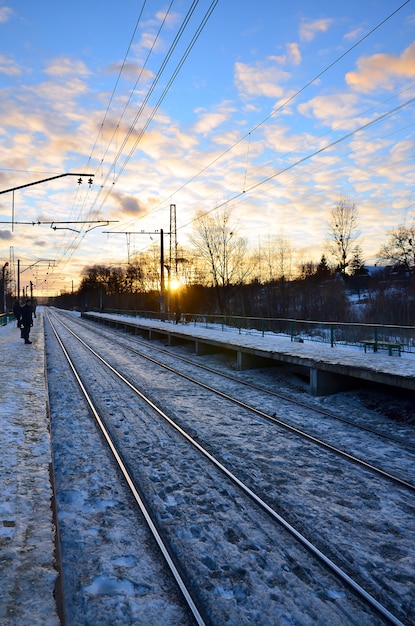 Het landschap van de avondwinter met het station