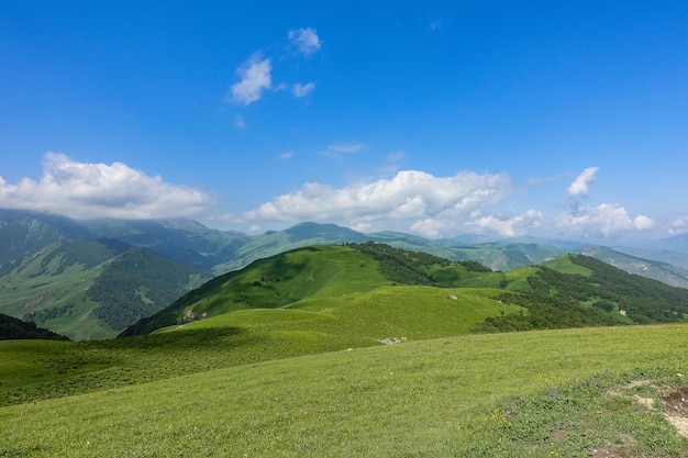 Het landschap van de groene Aktoprak-pas in de Kaukasus, de weg en de bergen onder grijze wolken KabardinoBalkarië, Rusland