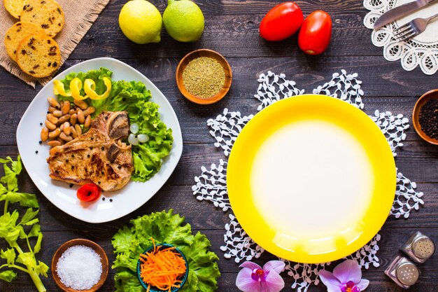 Het lapje vlees van het varkensvleeslapje vlees het eigengemaakte koken met kruiden verlaat sla op houten scherpe raad