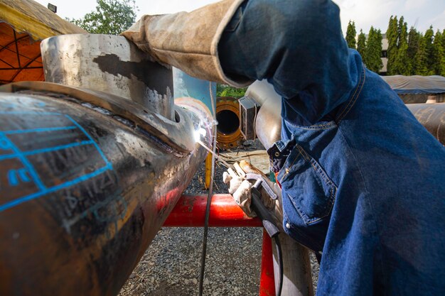 Het lassen van metaal voor mannelijke werknemers maakt deel uit van de pijpleidingconstructie van machines, aardolie en gas