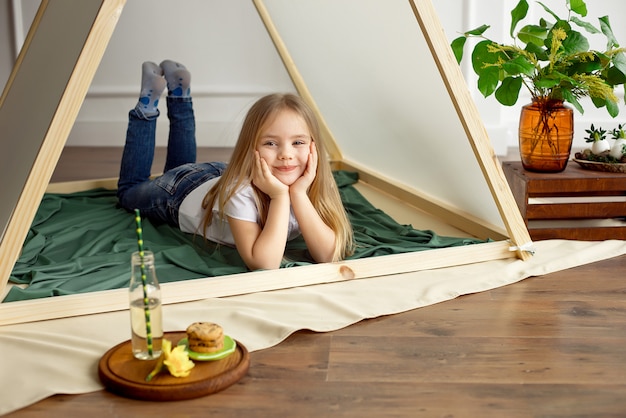 Het leuke gelukkige meisje stellen in een tent