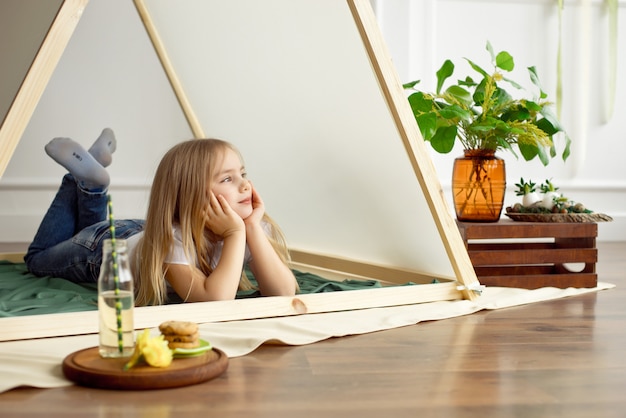 Het leuke gelukkige meisje stellen in een tent