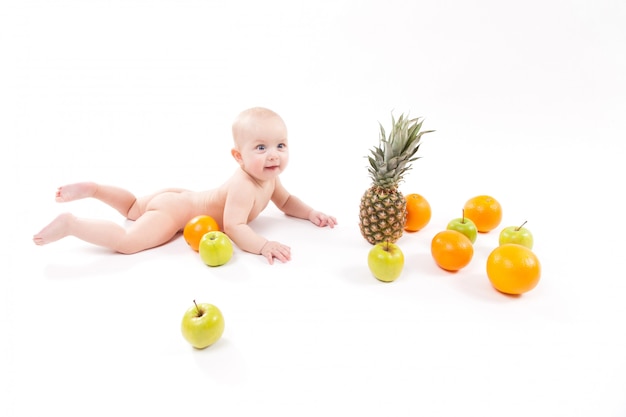 Het leuke glimlachende gezonde kind ligt onder fruit