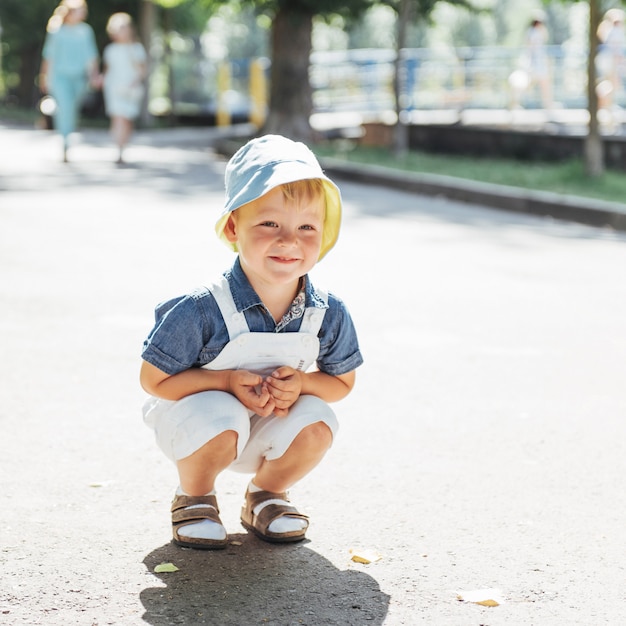 Het leuke jongen stellen voor foto in openlucht