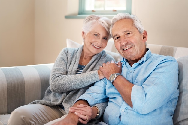 Het leven draait om de mensen die belangrijk voor je zijn Shot van een senior koppel dat samen thuis op de bank ontspant