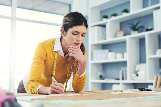 Het leven draait om het gebruik van de hele doos kleurpotloden Bijgesneden opname van een aantrekkelijke jonge modeontwerper in haar atelier