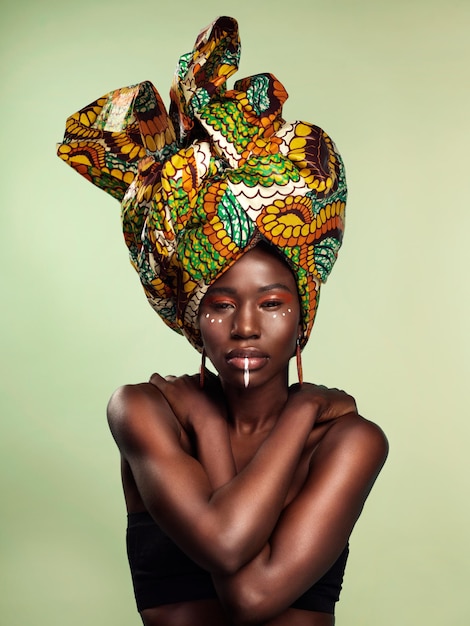 Het leven is mooi en jij ook Studio-opname van een mooie jonge vrouw die een traditionele Afrikaanse hoofddoek draagt tegen een groene achtergrond