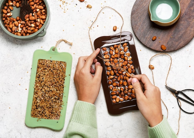 Het lint, touw of touw in elke chocoladerepen rijgen om op te hangen