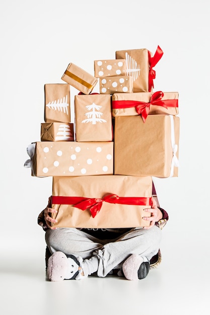 Het lot van geschenkdozen in de handen van jonge vrouw op witte studio achtergrond