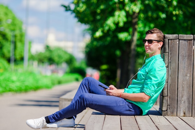 Het luisteren van de jongen muziek door smartphone op de zomervakantie