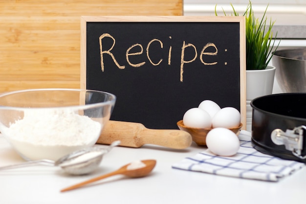 Het maken van deeg voor brood of zelfgemaakt gebak. ingrediënten op tafel. receptenbord