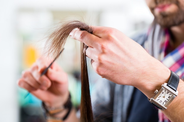 Foto het mannelijke haar van de kapper scherpe vrouw in kapperwinkel