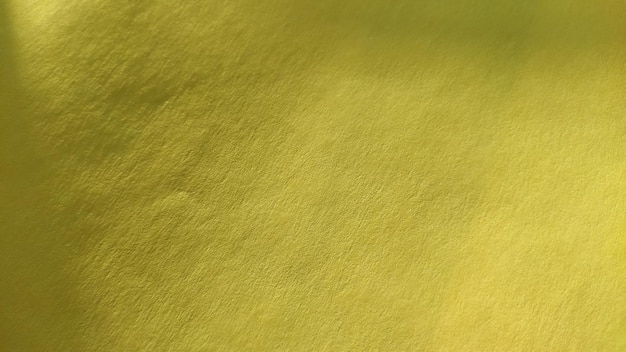 Het materiaal van papier of stof is felgeel Close-up Licht gevouwen vel Licht verloop en geaccentueerde ruwe oppervlaktetextuur Achtergrond of productmonster Zonnig vrolijk geel