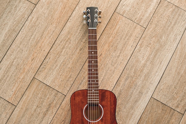 Het meest elegante instrument bovenaanzicht van de bruine akoestische gitaar liggend op de houten