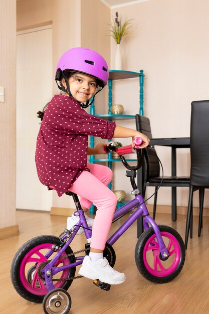 Het meisje berijdt een fiets in haar woonkamer