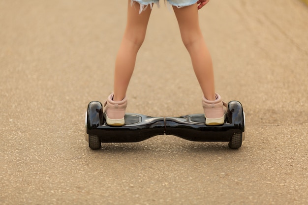 Het meisje berijdt een giroskuter in de zomer op het vierkant