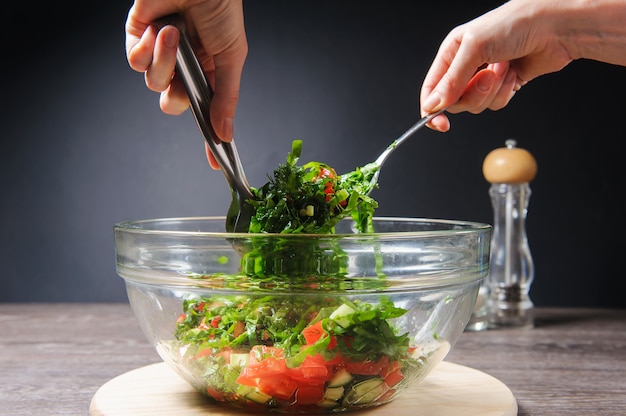 Het meisje beweegt gekookte vegetarische groentesalade