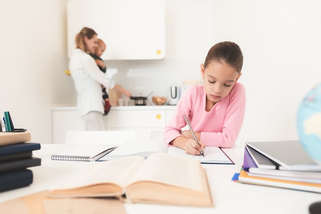 Het meisje die huiswerkmamma doen bevindt zich erachter.