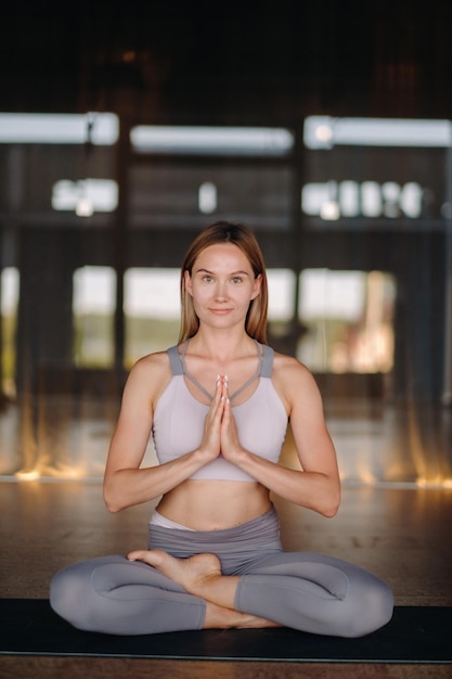 Het meisje doet yoga Een vrouw in sportkleding doet yoga-oefeningen in de sportschool