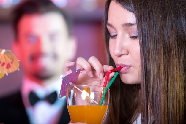 Het meisje drinkt een heerlijke cocktail in de bar.