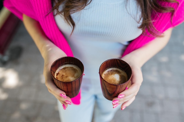 Het meisje drinkt koffie Meisje houdt koffie in haar handen Heerlijke cappuccino in de handen van een meisje Koffie en cappuccino in de hand Goedemorgen Heerlijke koffie