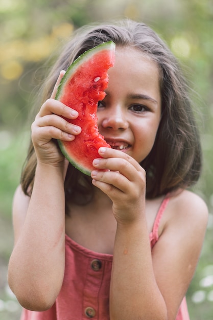 Het meisje eet een watermeloen. Zomerstemming.