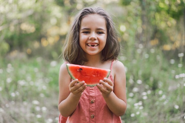 Het meisje eet een watermeloen. Zomerstemming.