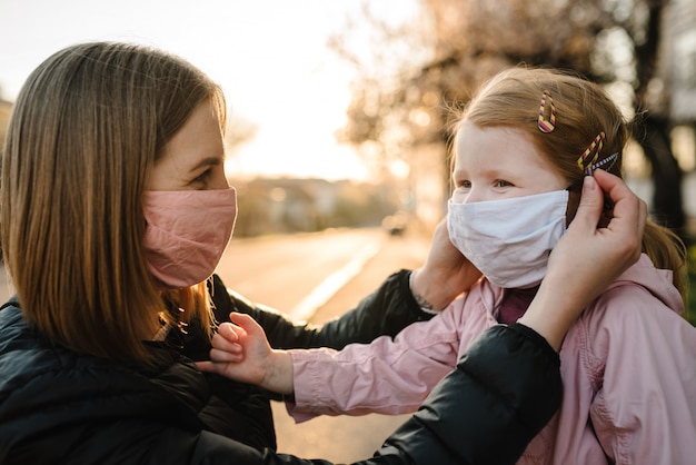 Het meisje en de moeder dragen maskers op straat