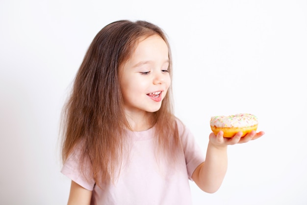 Het meisje gaat de donut afbijten Lekker en zoet Schadelijk eten