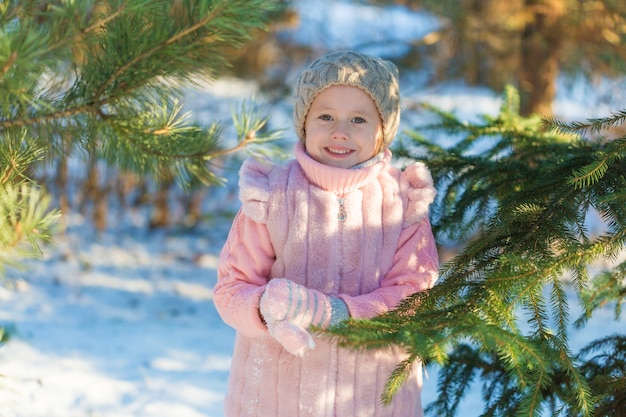 Het meisje glimlacht in de Winterbos. Gelukkige jeugd. Kids Outdoors.Winter Fun Holiday Concept