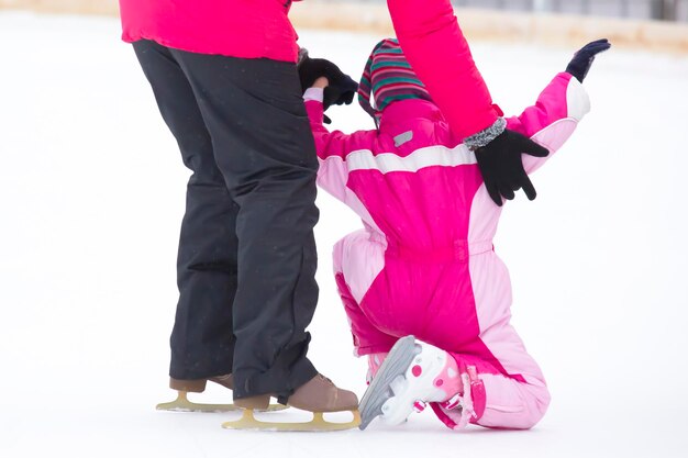 Foto het meisje helpt het kind schaatsen