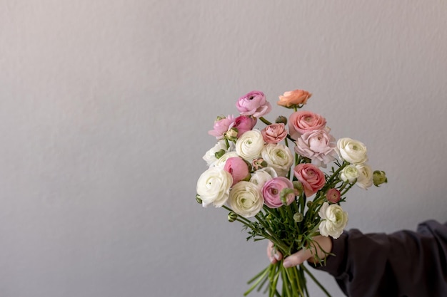 Het meisje houdt een boeket bloemen vast Ranunculus lentebloem Plaats voor tekst