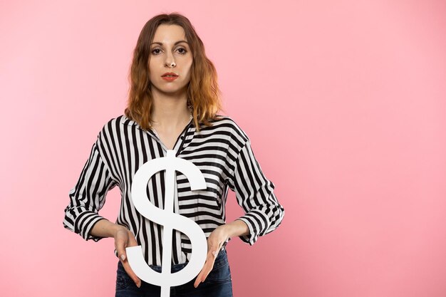 Foto het meisje houdt een groot dollar symbool in haar handen de vorm van de amerikaanse munt symbool van financiën en